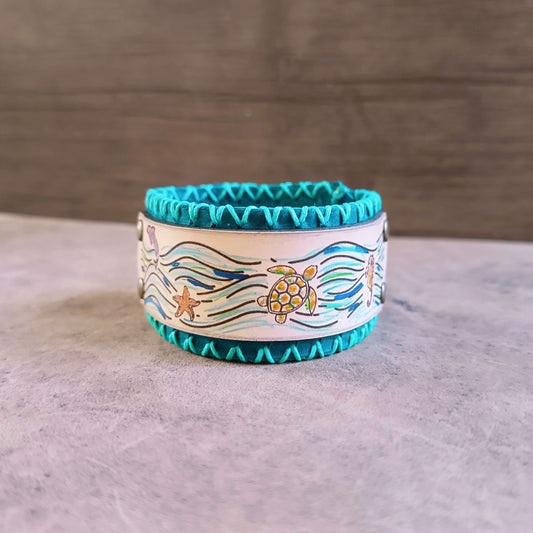 Wristband with ocean-themed design featuring a turtle and starfish on a neutral background