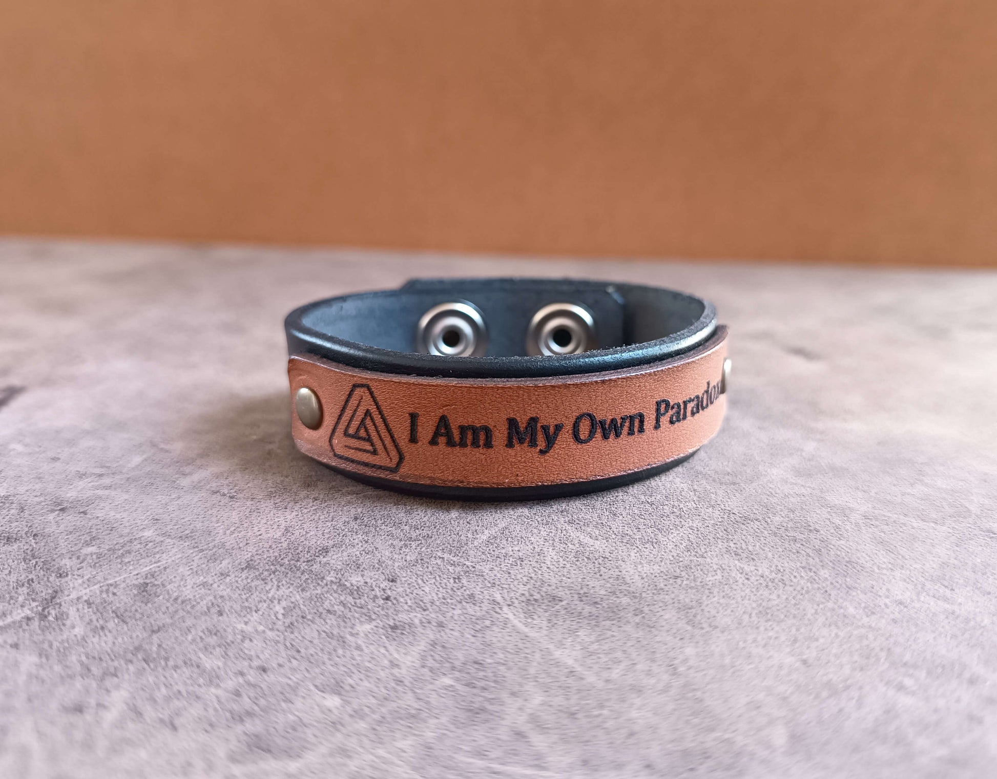 Leather bracelet with motivational quote on a textured surface