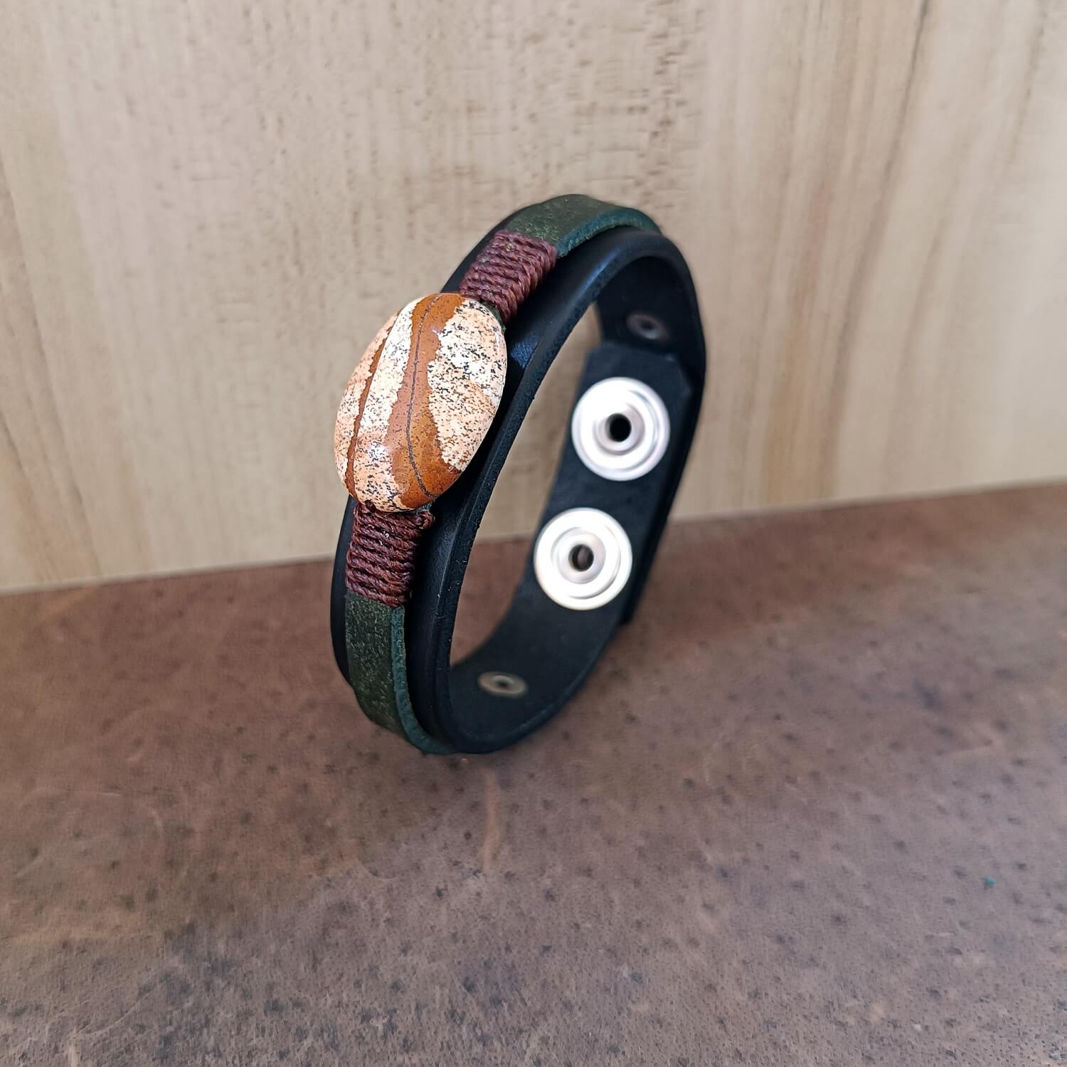 Black and green layered leather bracelet featuring a large oval natural picture jasper stone, close up sideway view showcasing leather thickness and smooth edges