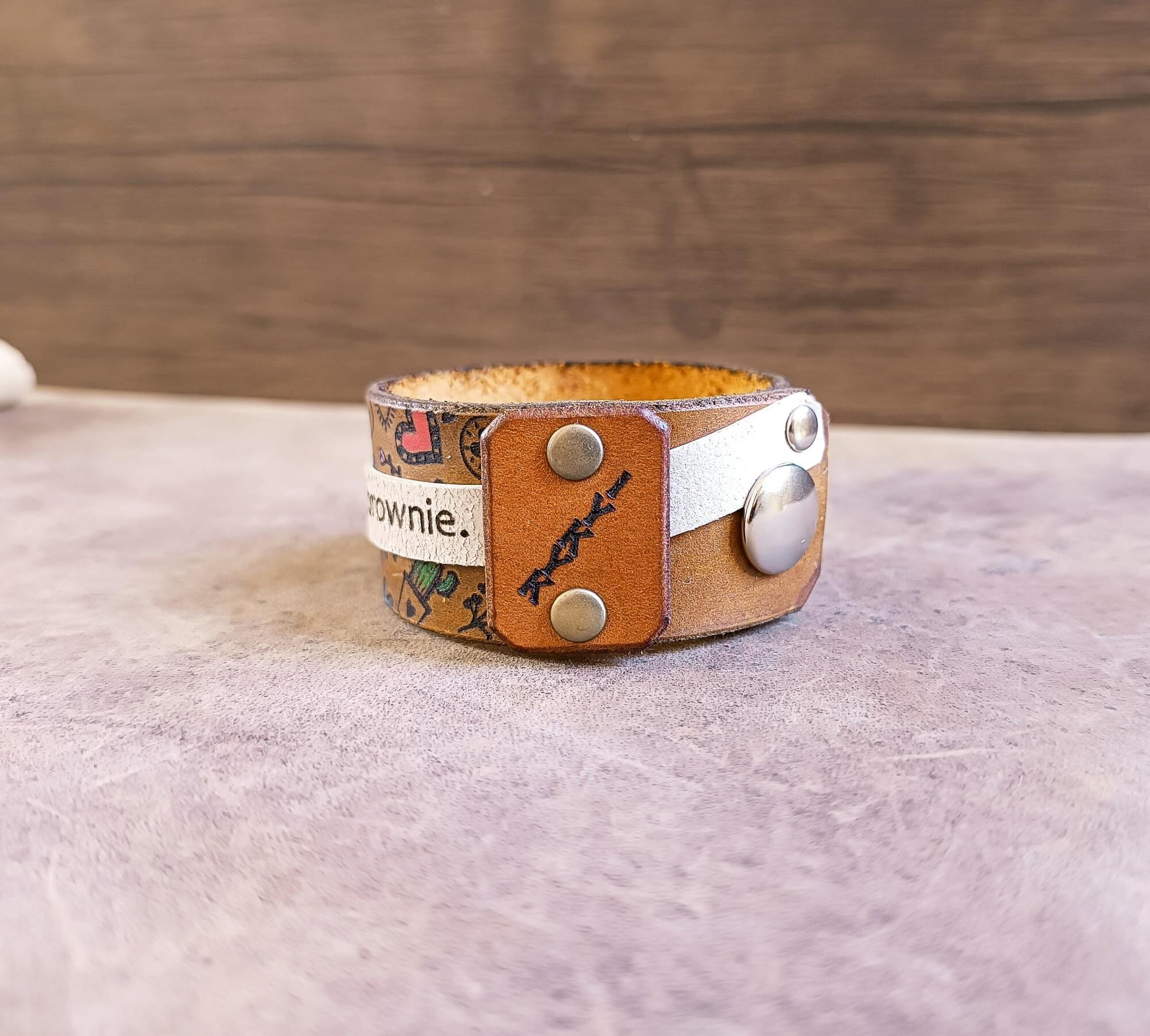 Leather bracelet with decorative elements on a textured surface