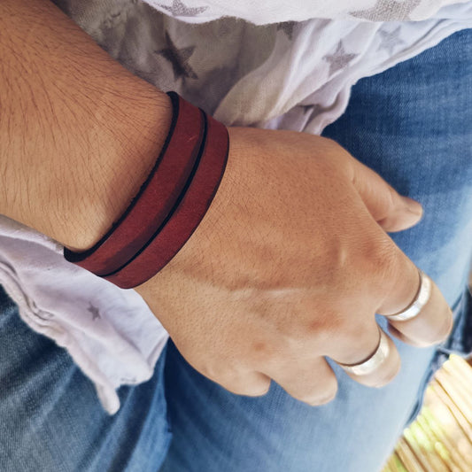 Red leather choker cuff worn on woman's wrist, showing bold color and fit