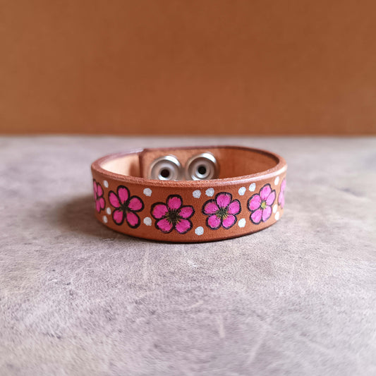 Leather bracelet with pink floral patterns on a neutral background