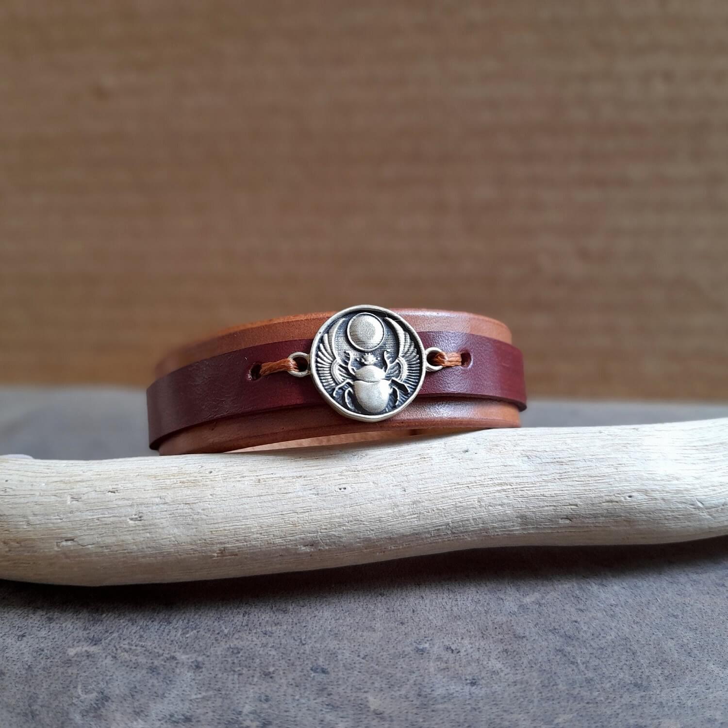 Close-up of brass scarab charm, showcasing handmade texture and symbolic design.