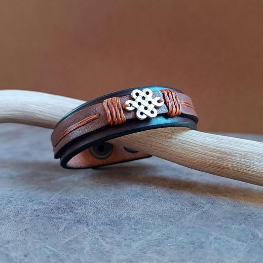 Celtic Shield Knot Leather Bracelet for Men on driftwood, showing beautiful brown hues