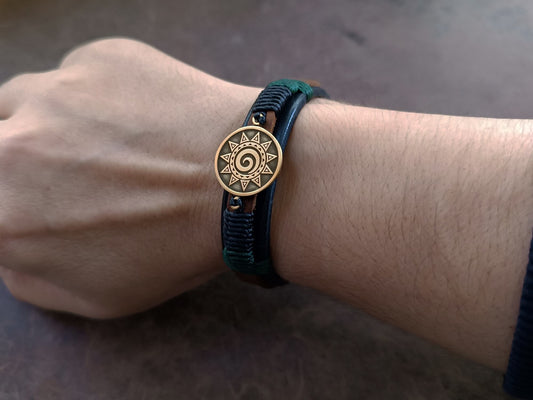 Unisex leather Koru bracelet worn on wrist, showing its slim 1.5 cm width and adjustable stud button closure.