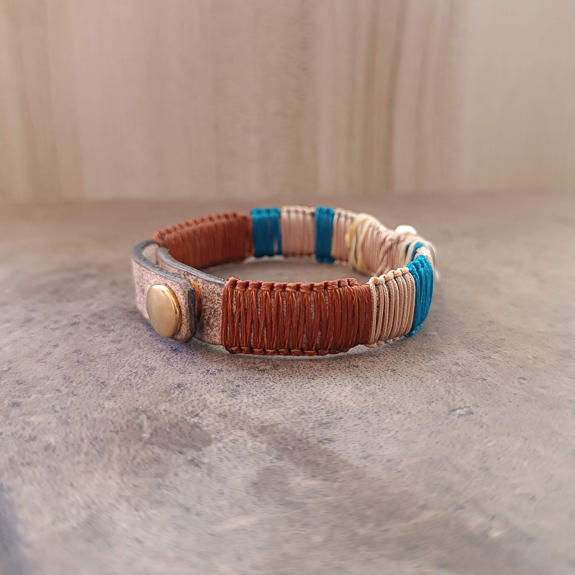 Bracelet with brown, beige, and blue pattern on a neutral background