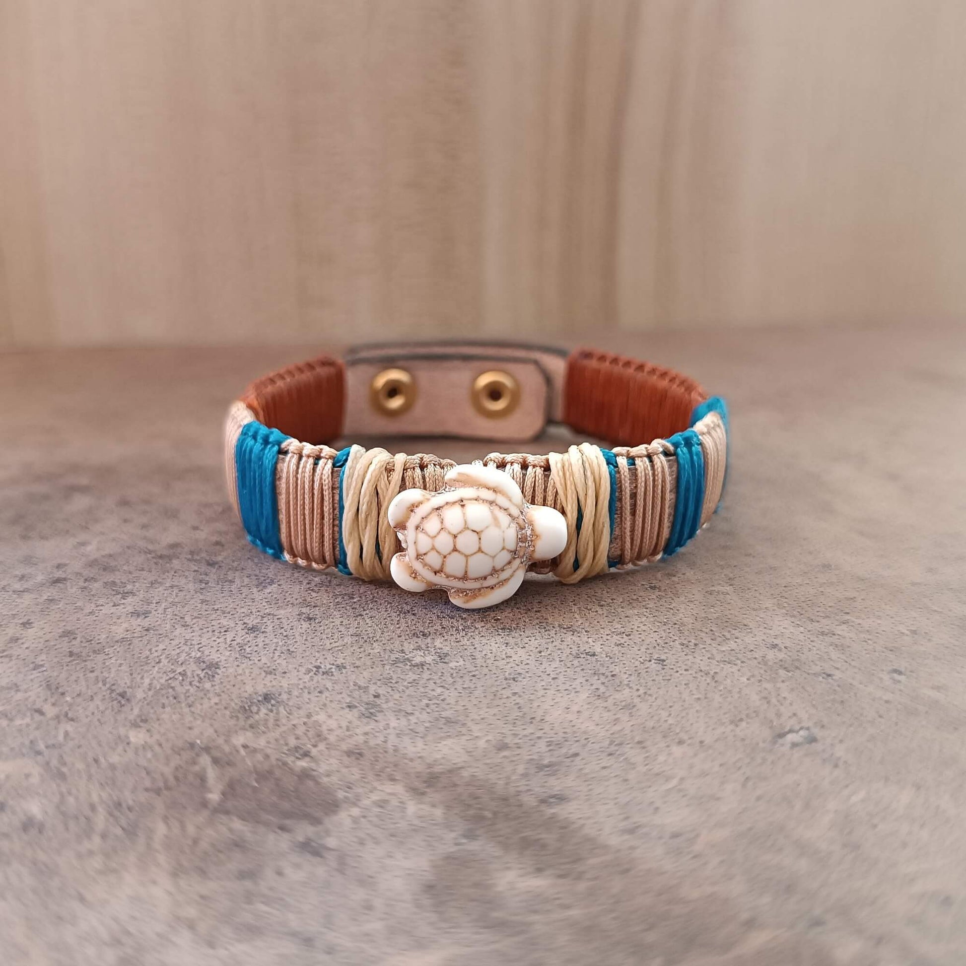 Bracelet with turtle charm on a textured surface