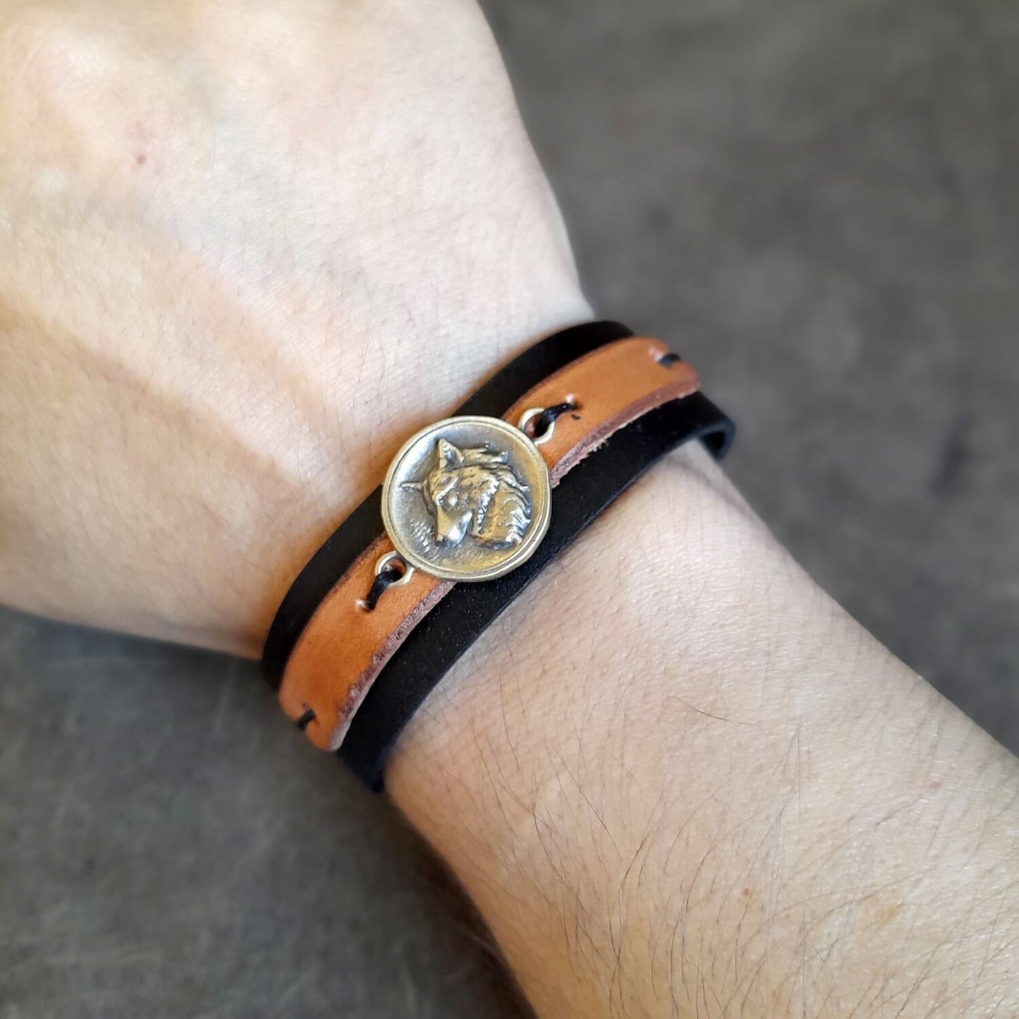 Black and brown leather wolf bracelet worn on wrist