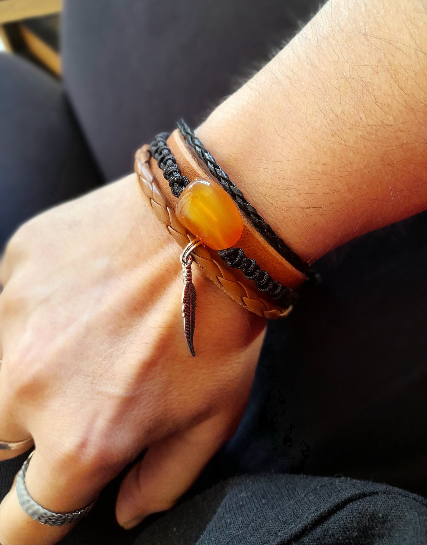a multistrand leather cuff bracelet worn on wrist, featuring a large Sardonyx stone and braided cords