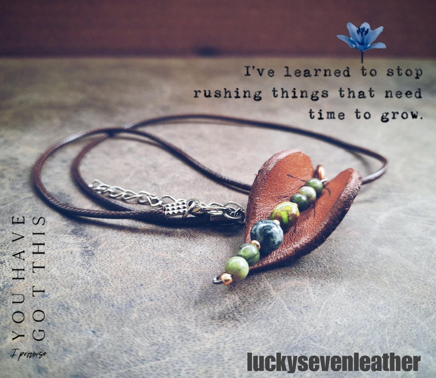 an inspirational poster with quotes and a handmade leather leaf pendant necklace with green jasper beads.