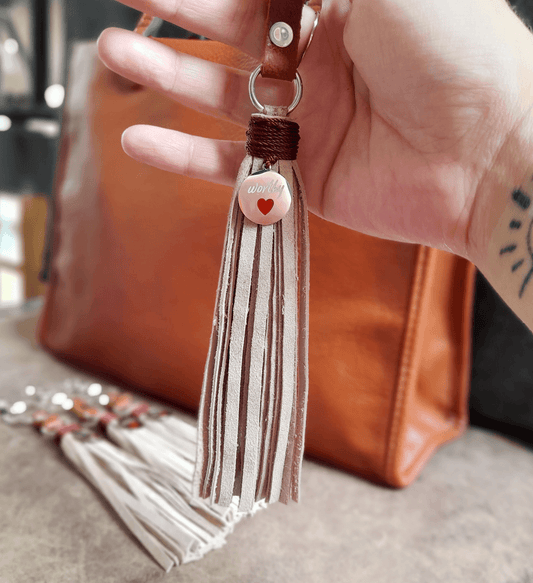Worthy Spirit | Bijou de sac à pompon en cuir beige avec pendentif en argent