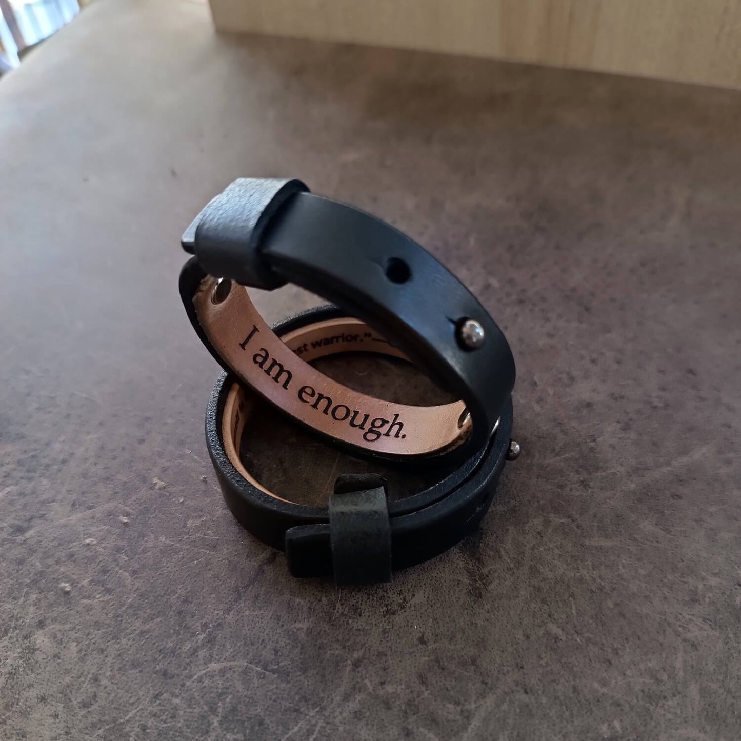 Close up of the Black Vachetta Leather Bracelets with engraved hidden message that reads "I am enough".