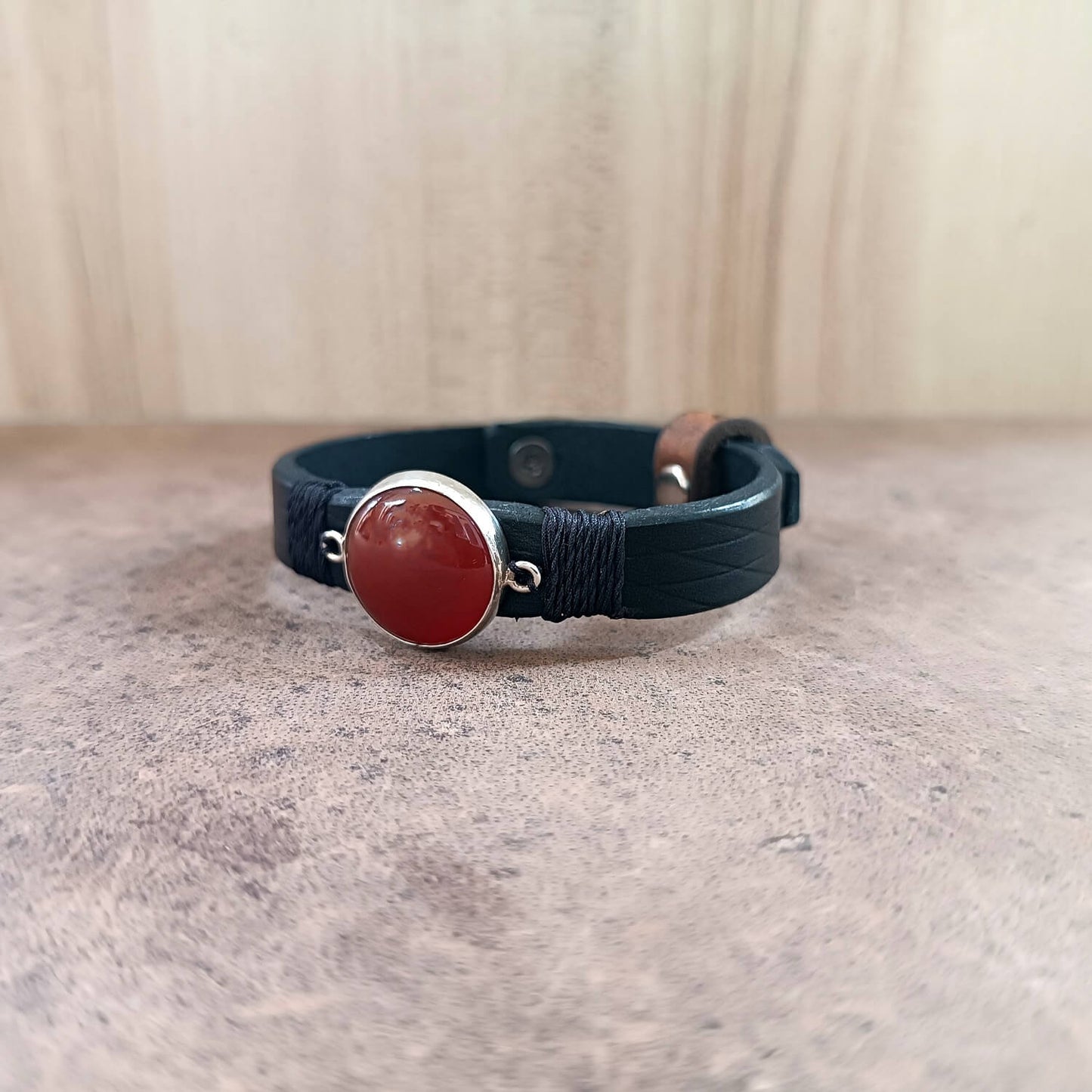 Bracelet with red stone and silver clasp on a neutral background