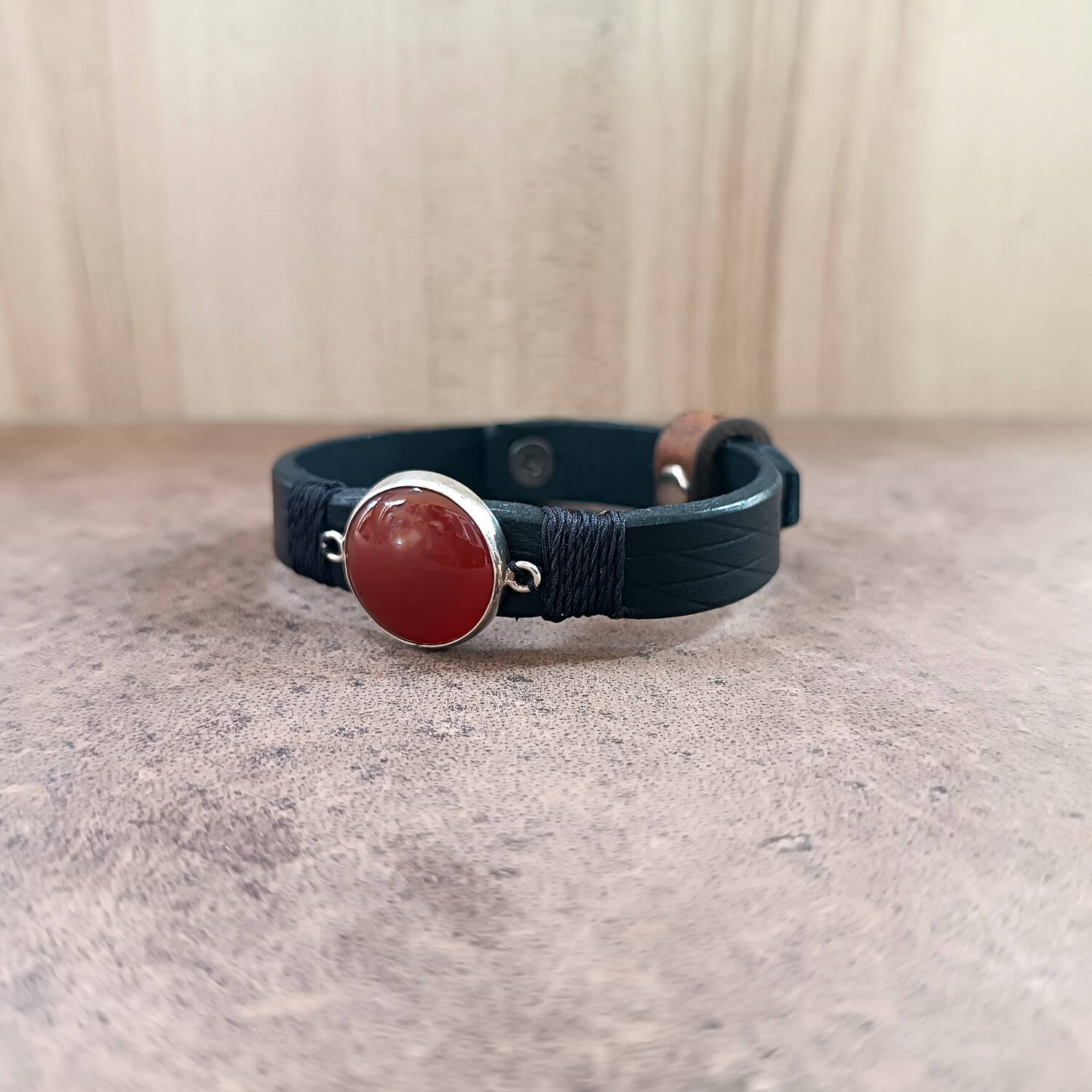 Bracelet with red stone and silver clasp on a neutral background