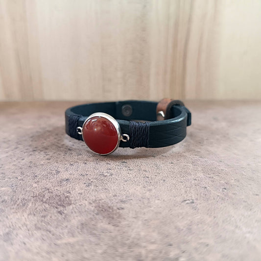 Bracelet with red stone and silver clasp on a neutral background