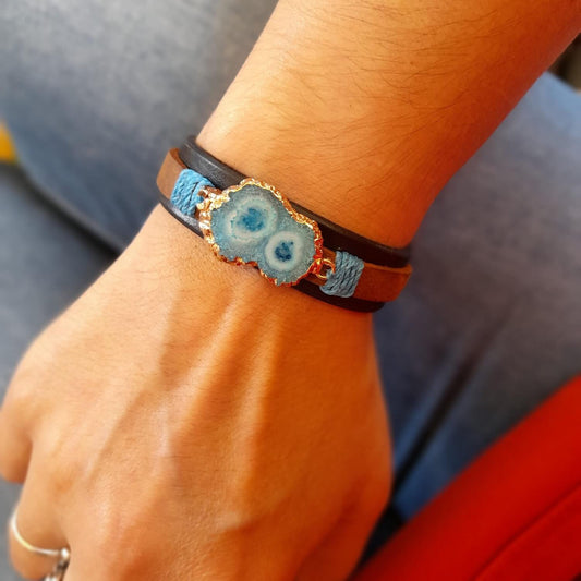 The Druzy Chrysocolla Leather Bracelet worn on a wrist, demonstrating its comfortable fit, layered design, and how it complements a casual outfit.