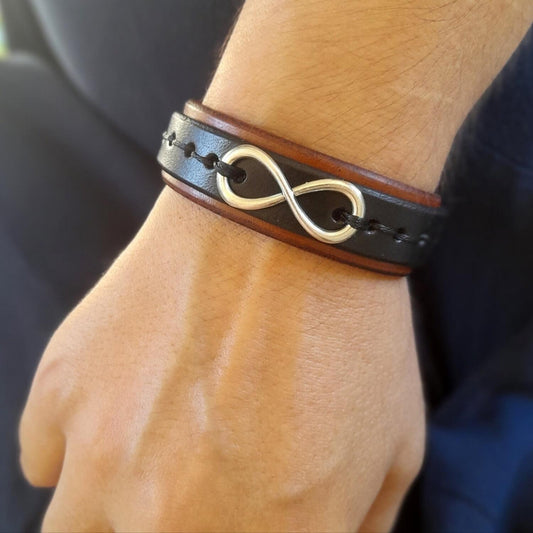 Bracelet with an infinity symbol on a wrist against a blurred background