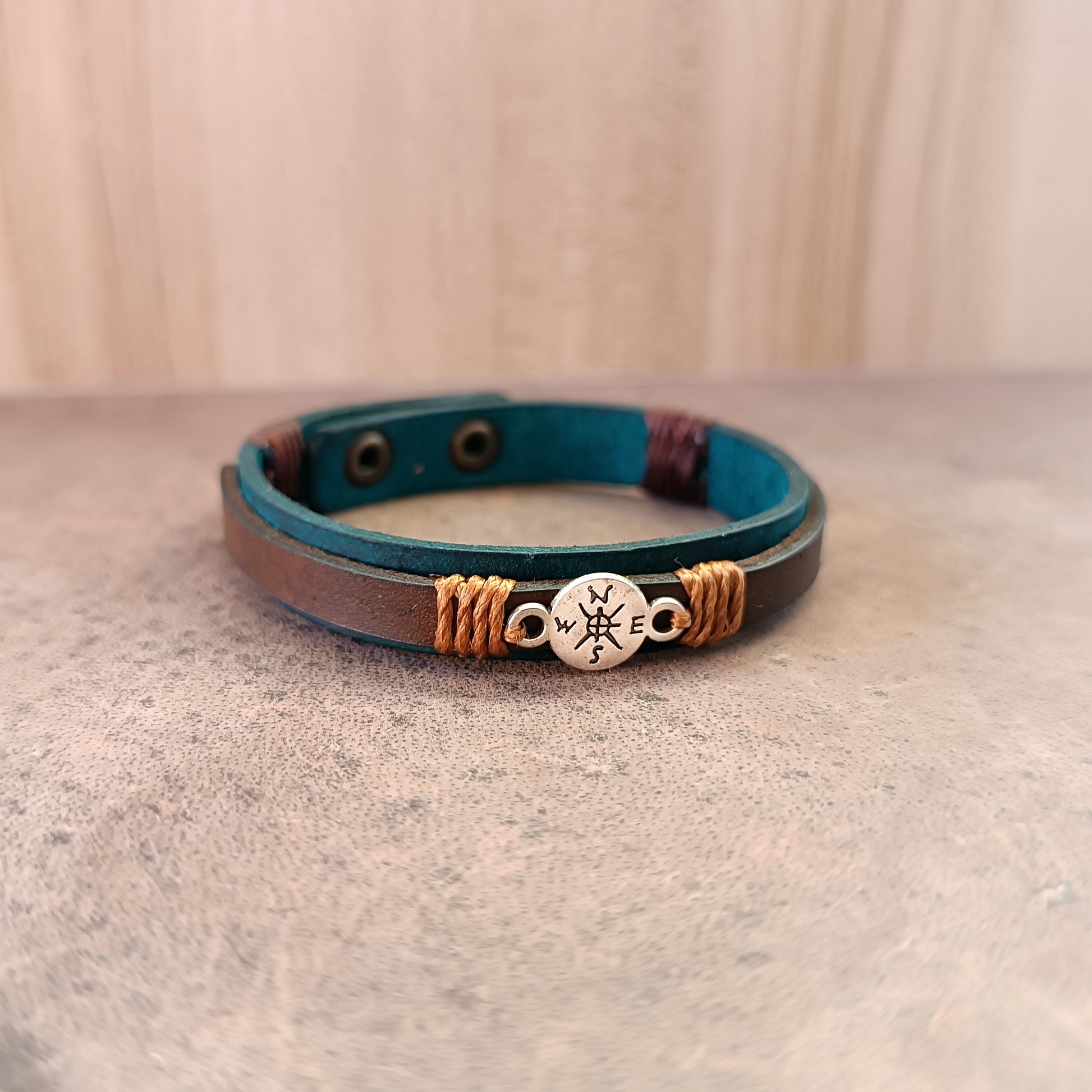 Inner Compass Leather Bracelet from Quiet Rebirth Collection. Handcrafted on petrol blue Crazy Horse leather with bubble-black dye technique, featuring a delicate silver compass charm.