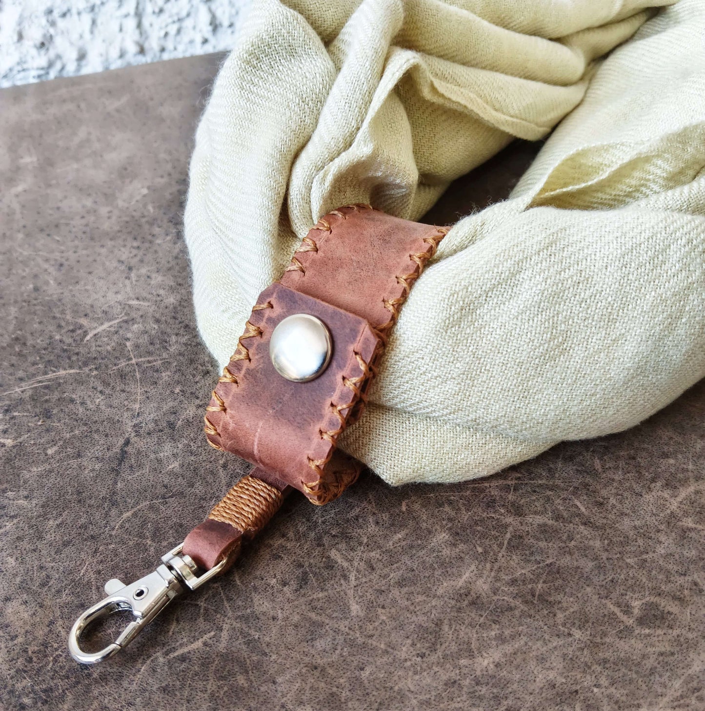 Leather scarf holder carrying a scarf