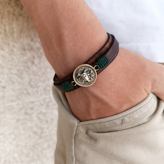 Medusa's Gaze Bracelet worn on wrist, showing its bold statement and comfortable fit. Highlights the Medusa charm against dark leather. Made by Lucky Seven Leather.