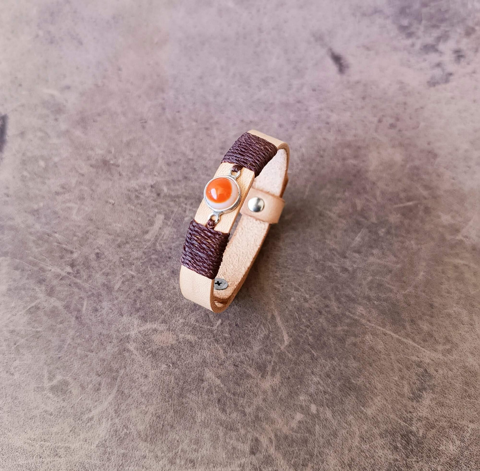 Side angle view of the OOAK beige leather bracelet featuring an Orange Carnelian Agate stone on sterling silver bezel