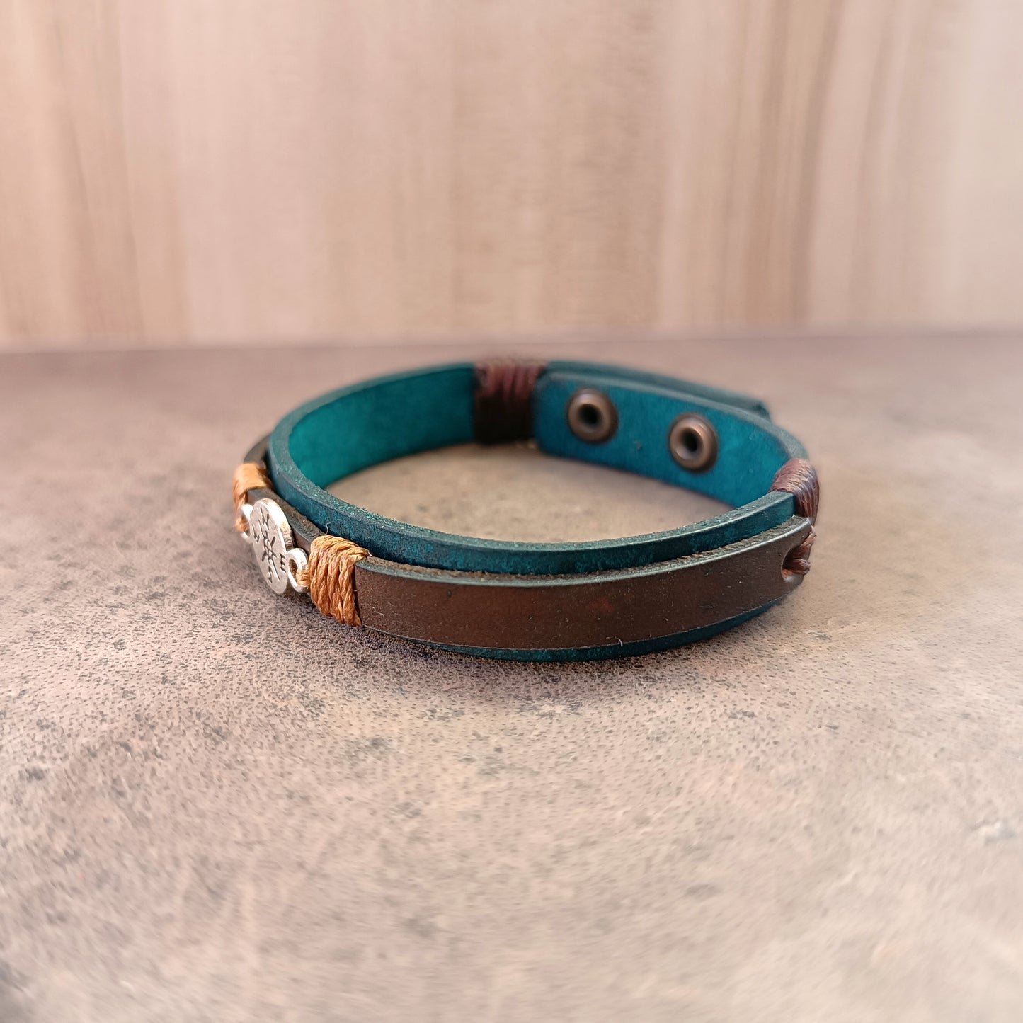 Other Side view of Inner Compass Leather Bracelet, showing layers of petrol blue and dark brown leather, and the silver compass charm.
