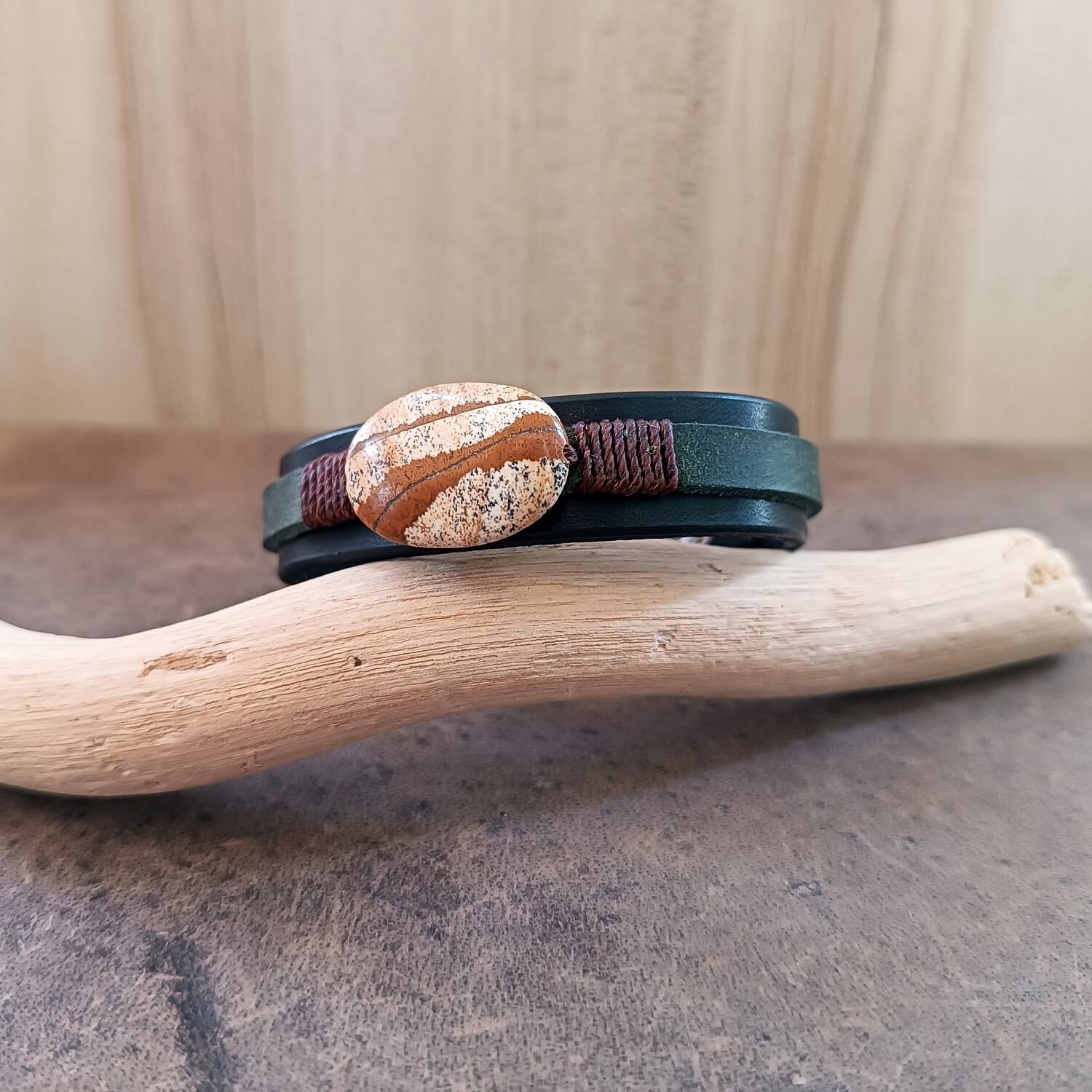 Black and green layered leather bracelet featuring a picture jasper stone, close up view