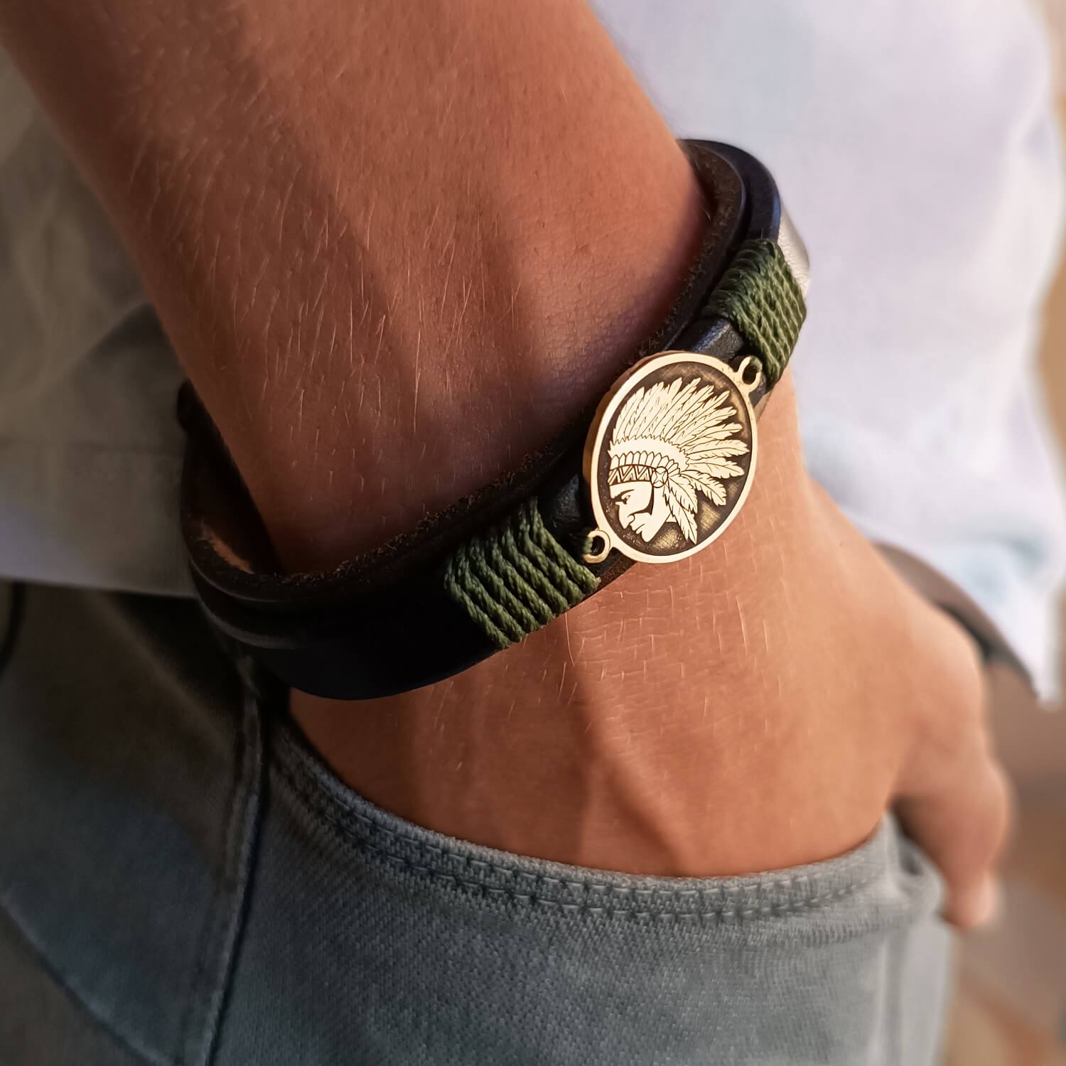 the Last Chief Bracelet worn on wrist. Black and dark brown leather, with desert green cord