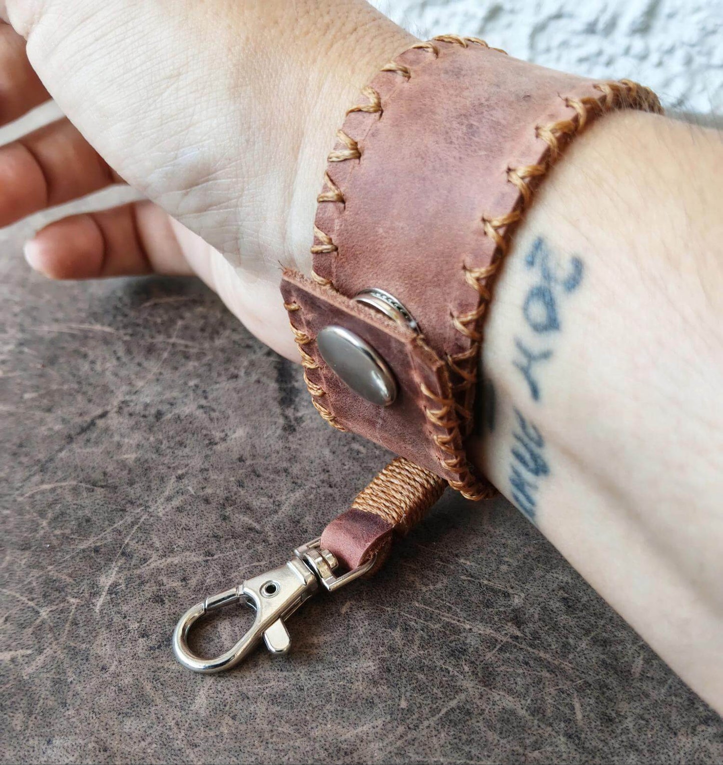 The Switchback dark brown leather cuff worn on the wrist, backside view of lobster clasp