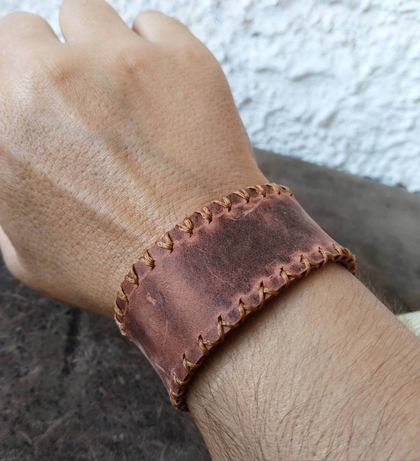 The Switchback dark brown leather cuff worn on the wrist
