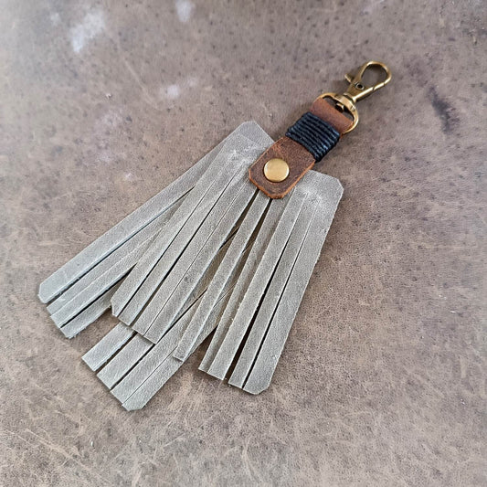 Leather tassel keychain with fringes on a textured surface
