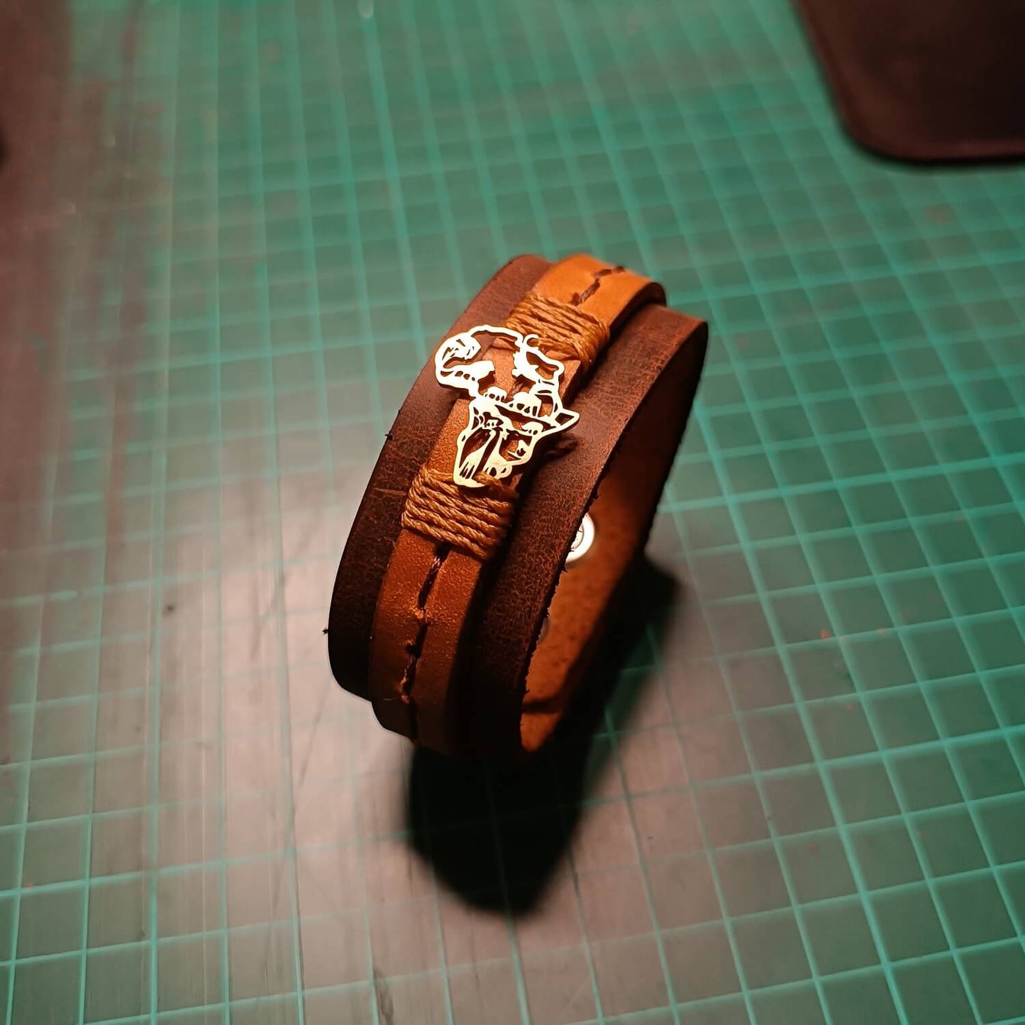 Brown leather bracelet with gold Africa Shaped pendant making of
