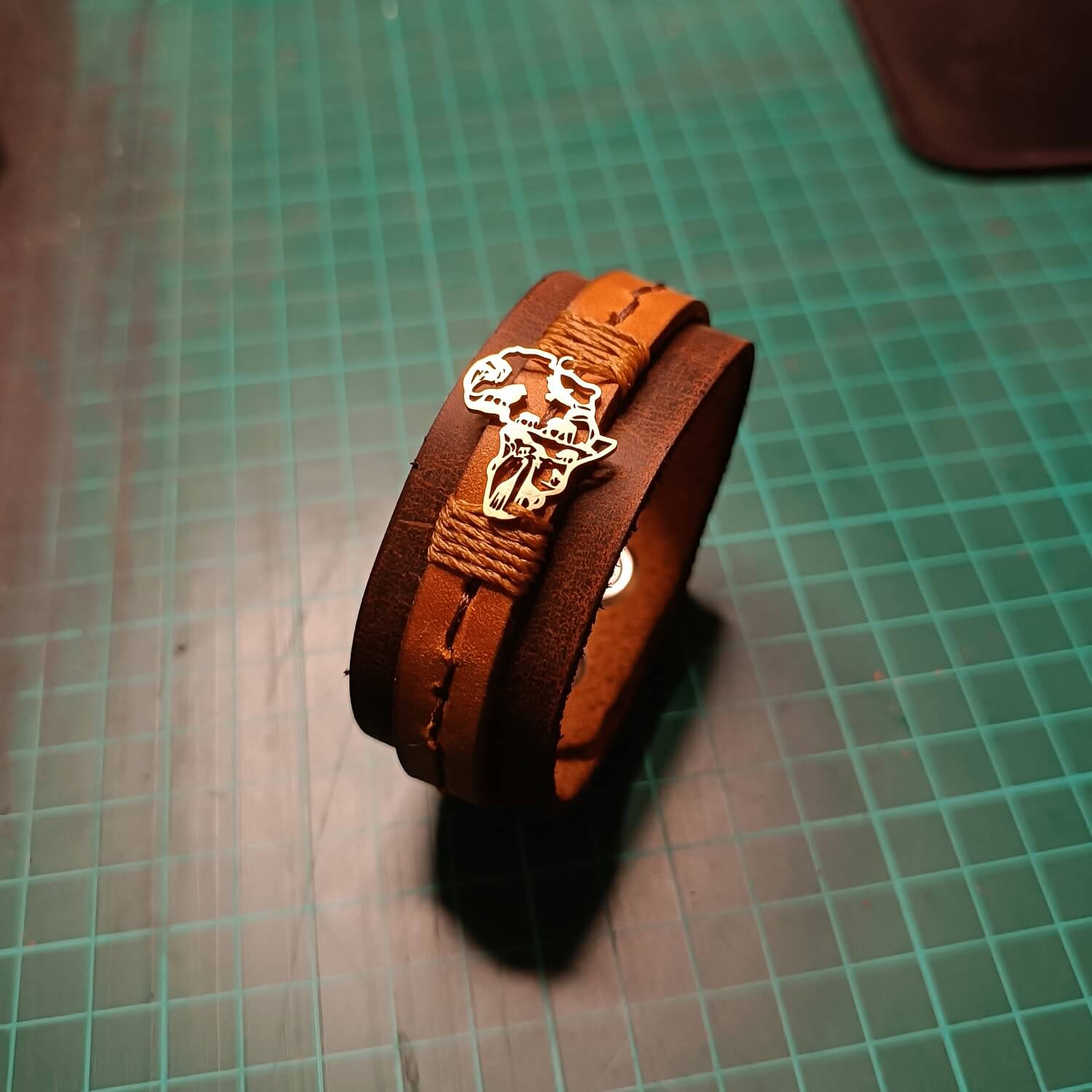 Brown leather bracelet with gold Africa Shaped pendant making of