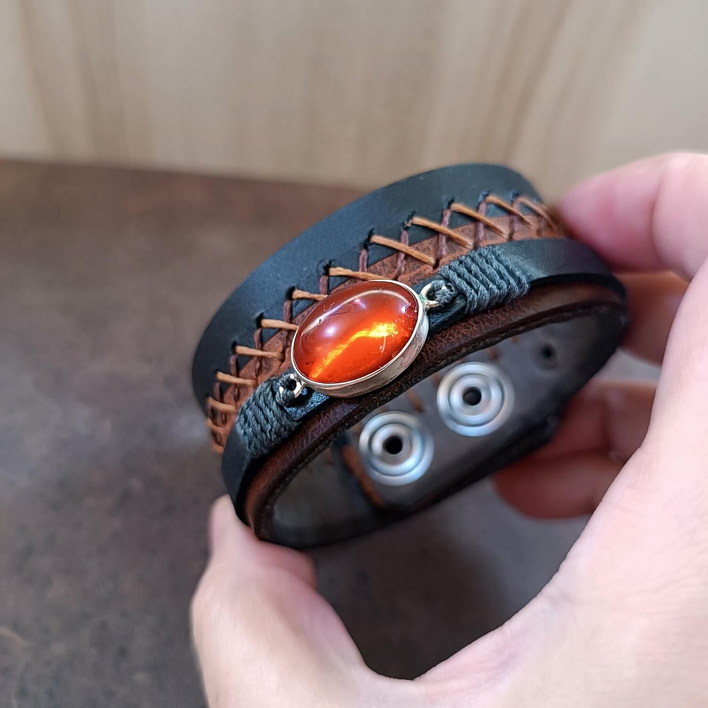 Close-up of rich, opaque natural Greek Amber in sterling silver setting, showing internal reflections and tiny captured treasures.