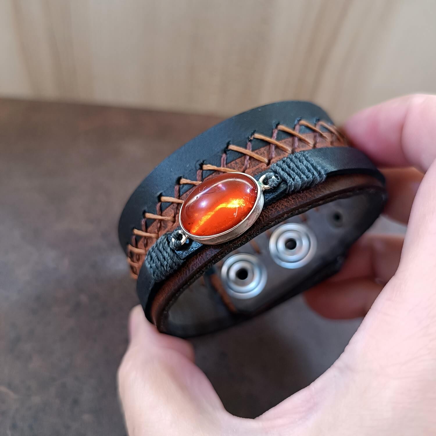 Close-up of rich, opaque natural Greek Amber in sterling silver setting, showing internal reflections and tiny captured treasures.