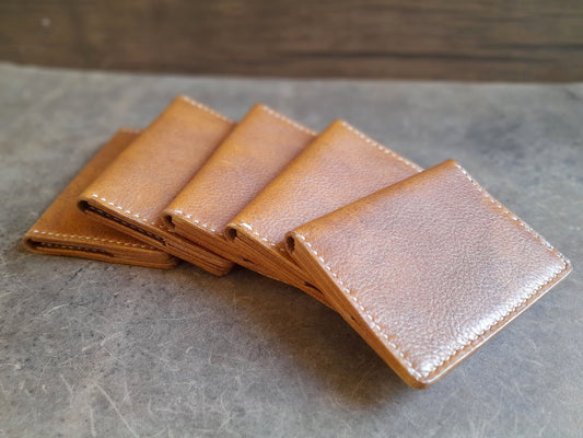 Minimalist handmade leather bi-fold wallet in brown full grain leather.