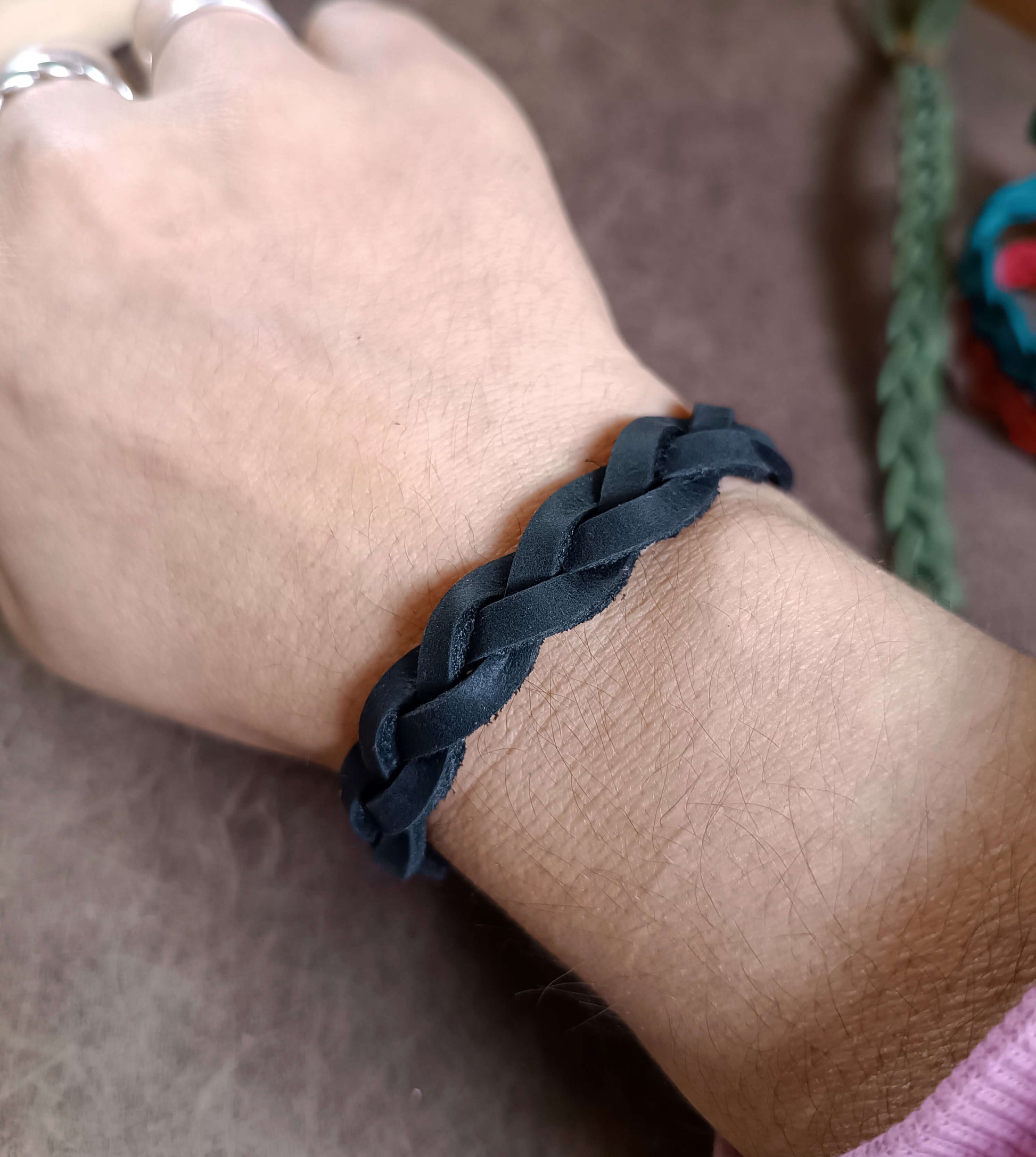 Black braided bracelet on a wrist 