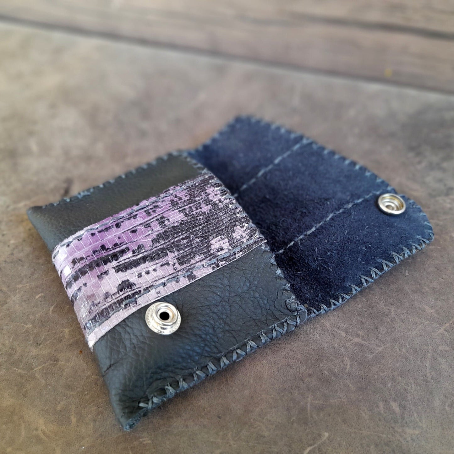 the black leather flap OOAK wallet, laying flat, showcasing its single large compartment