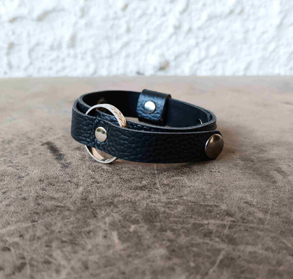 A black textured ringholder leather bracelet with silver-tone metal hardware.