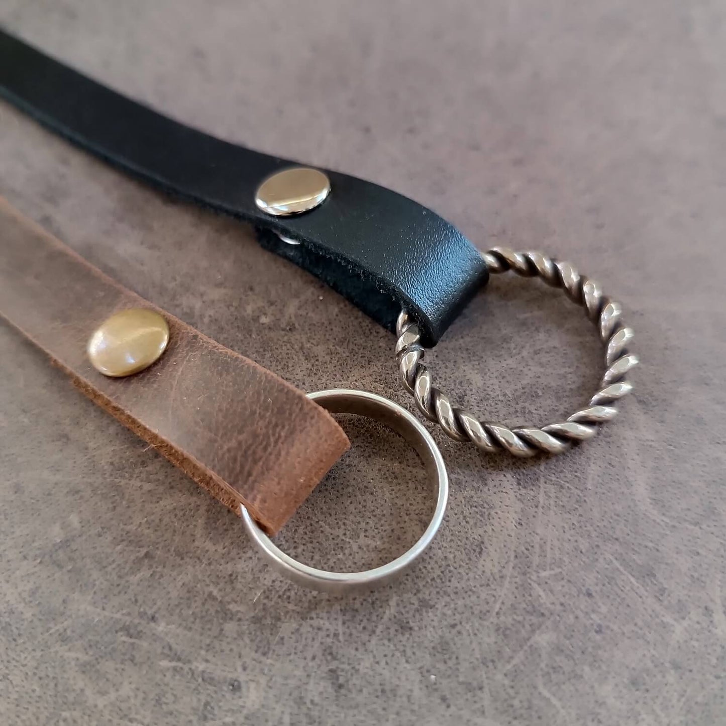 Detailed close-up photo showing the snap closure and the secure fit of the wedding bands on the ring button for the minimalist leather cuff.