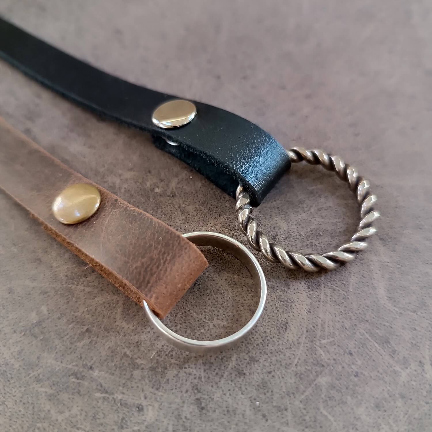 Detailed close-up photo showing the snap closure and the secure fit of the wedding bands on the ring button for the minimalist leather cuff.