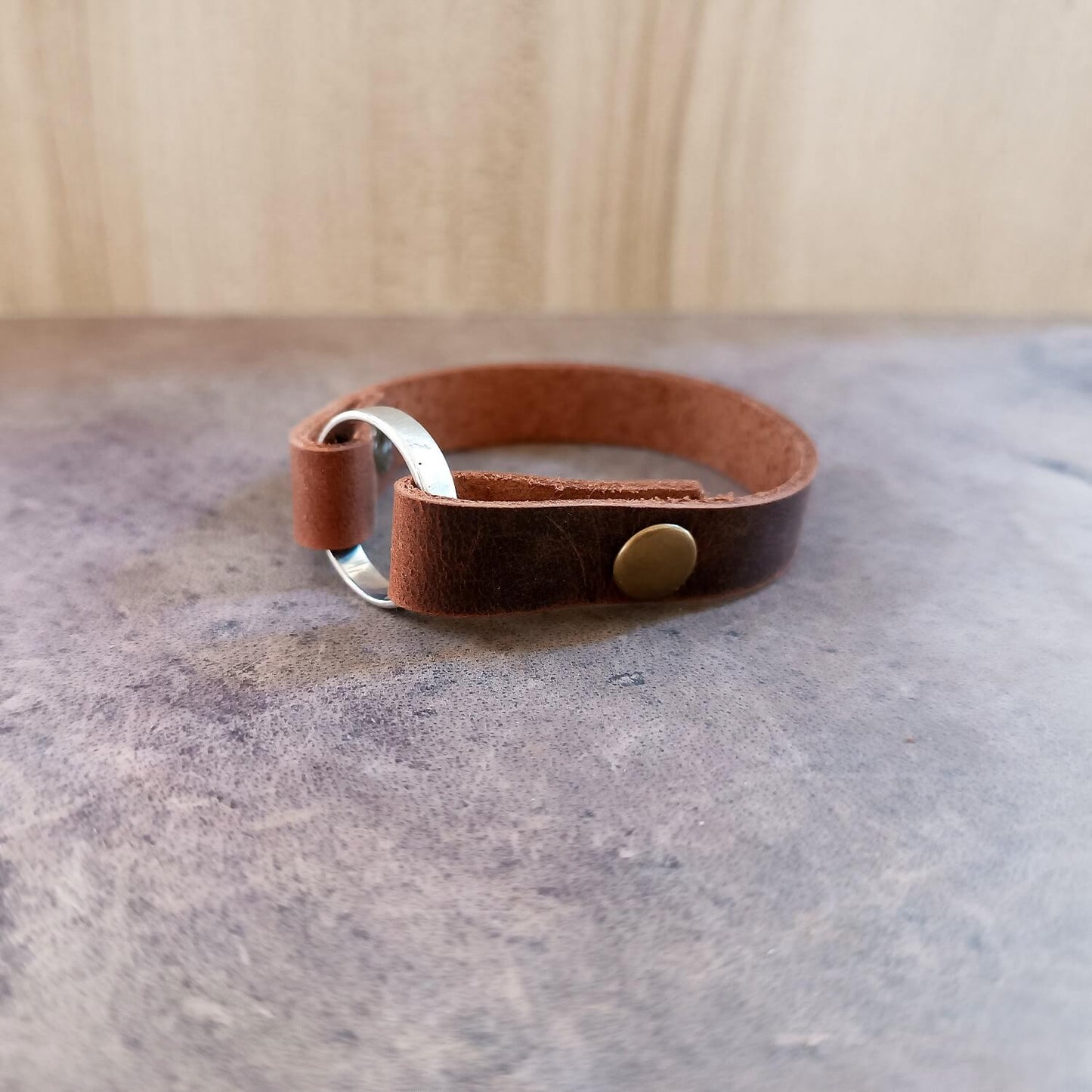 Front view of the Chestnut Brown leather ring keeper cuff (1.2 cm) with Antique Bronze snaps, showcasing the precise fold and ring button.
