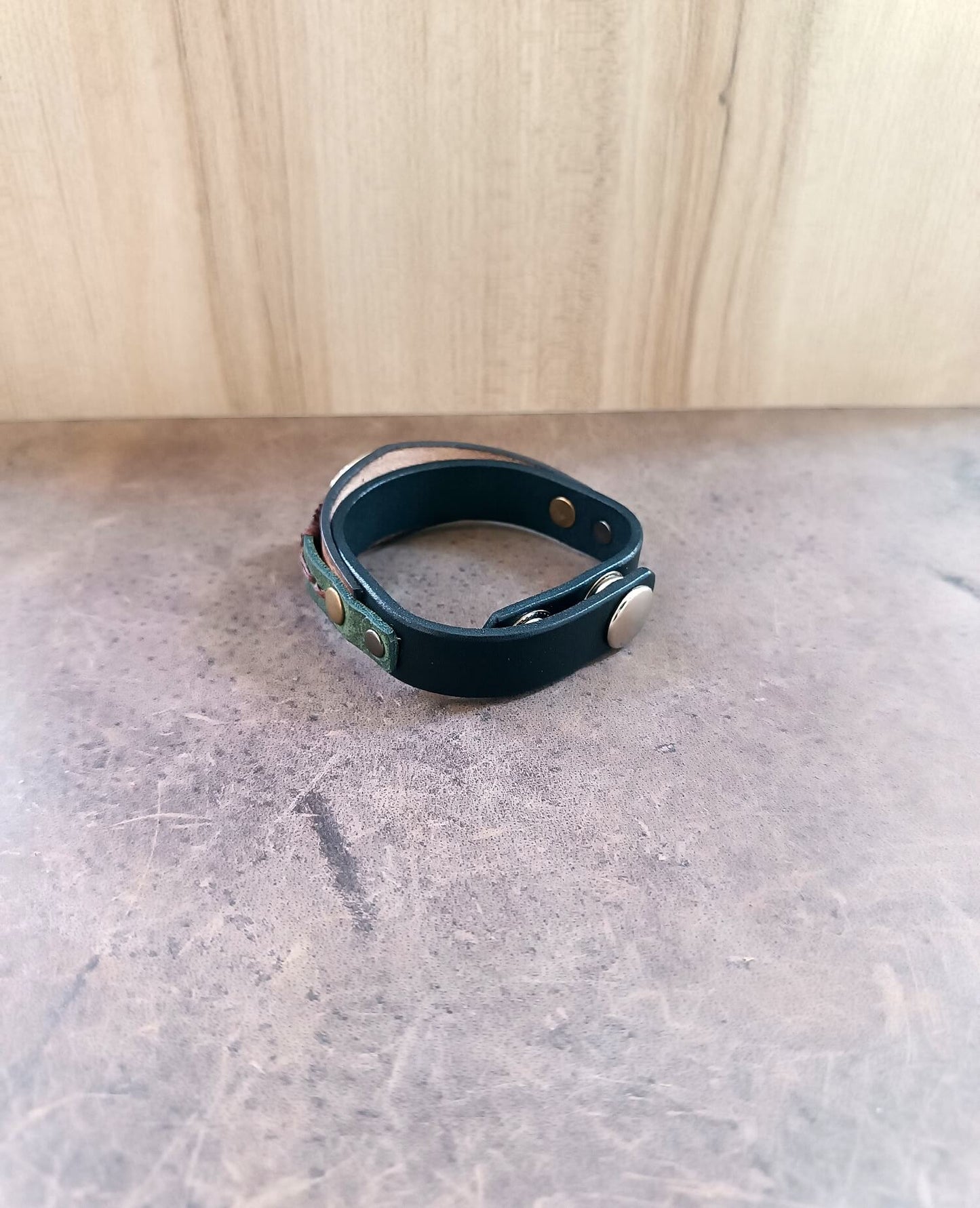 Close-up of the adjustable stainless steel snap buttons closure on the wide leather cuff, ensuring secure and comfortable fit.