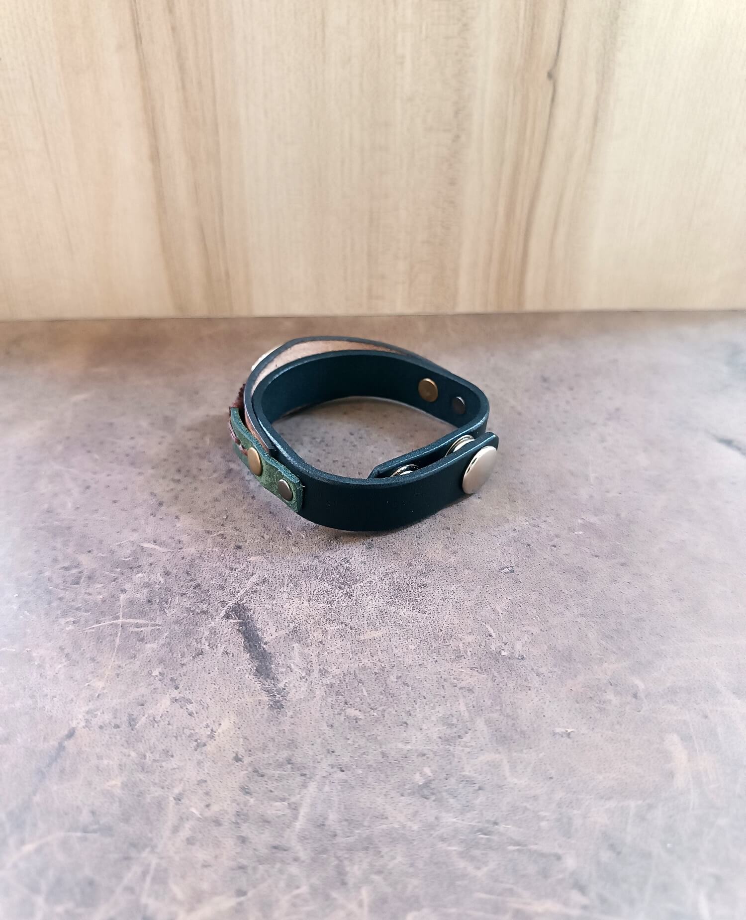 Close-up of the adjustable stainless steel snap buttons closure on the wide leather cuff, ensuring secure and comfortable fit.