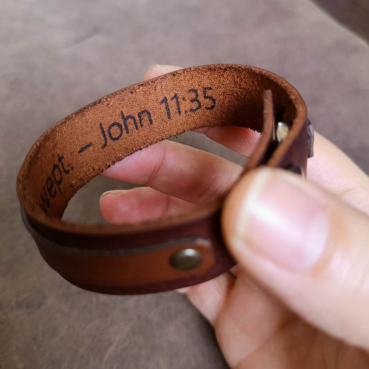 Underside of rose gold cross bracelet showing personalized engraving area