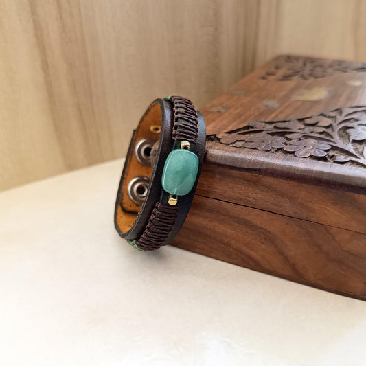 close up view of the green aventurine bracelet, resting sideways on a vintage wooden jewelry box