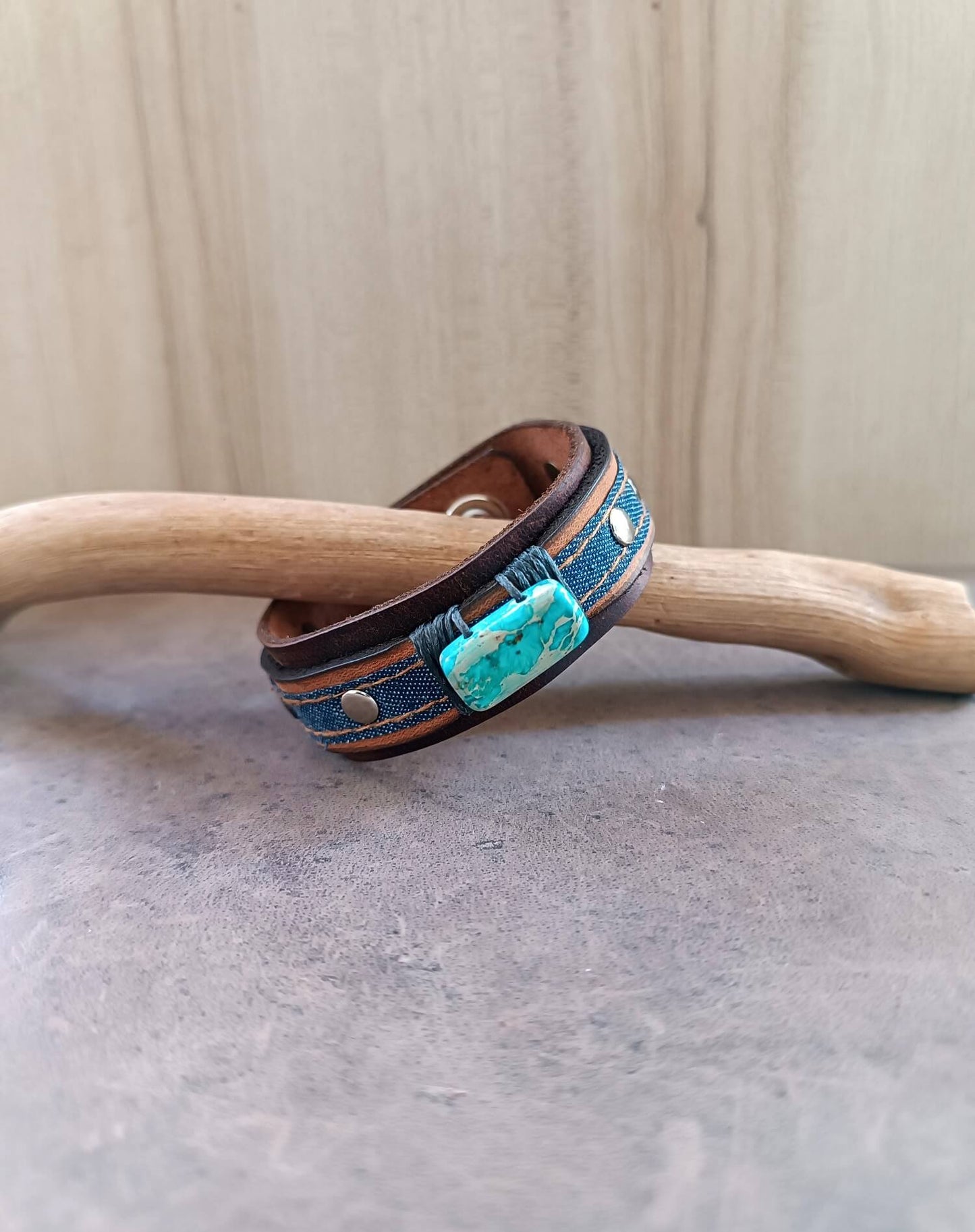 Side view of the Denim and Crazy Horse leather cuff, showcasing the Imperial Jasper stone and the rivets.