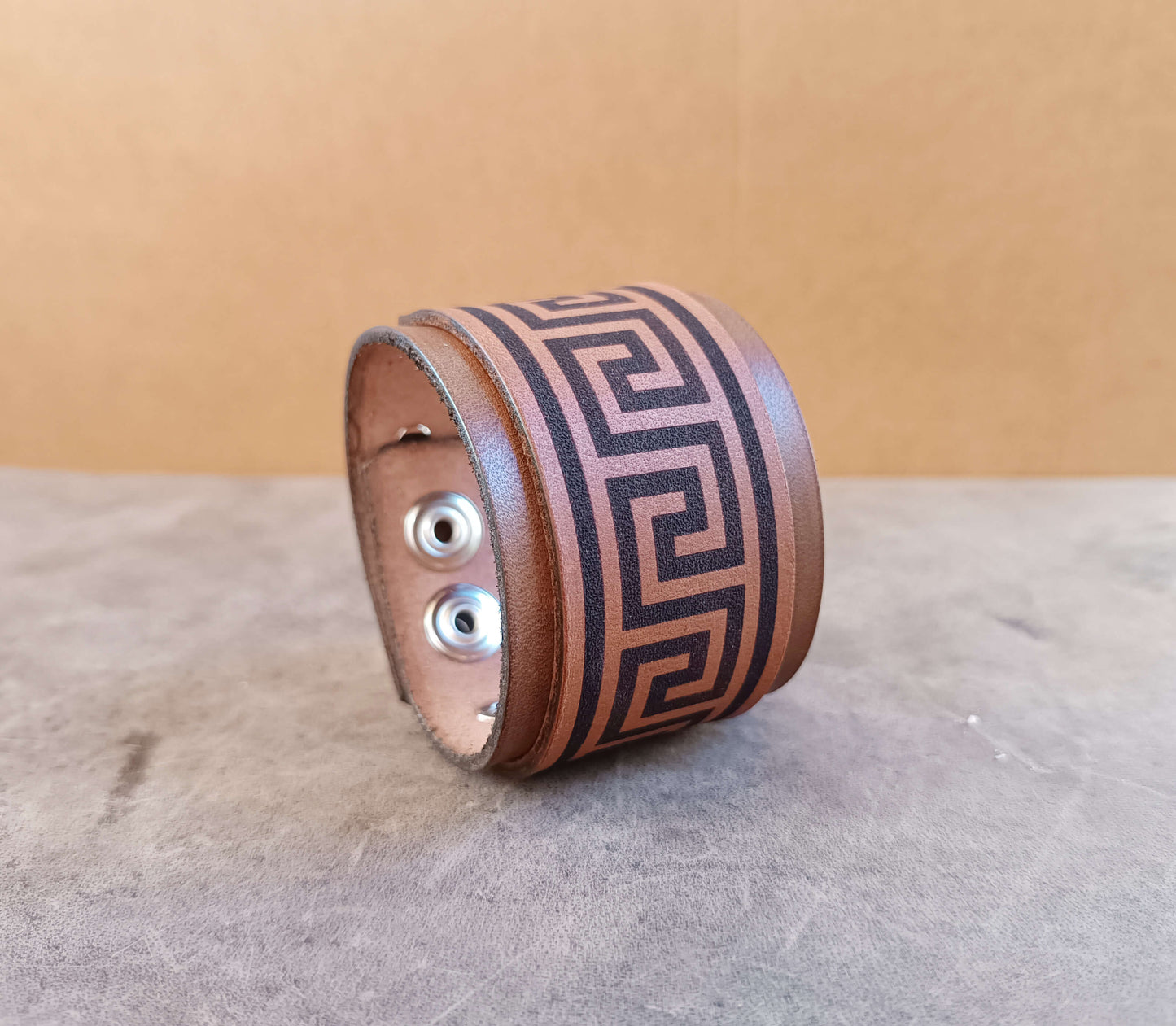Leather bracelet with meander pattern on a textured surface