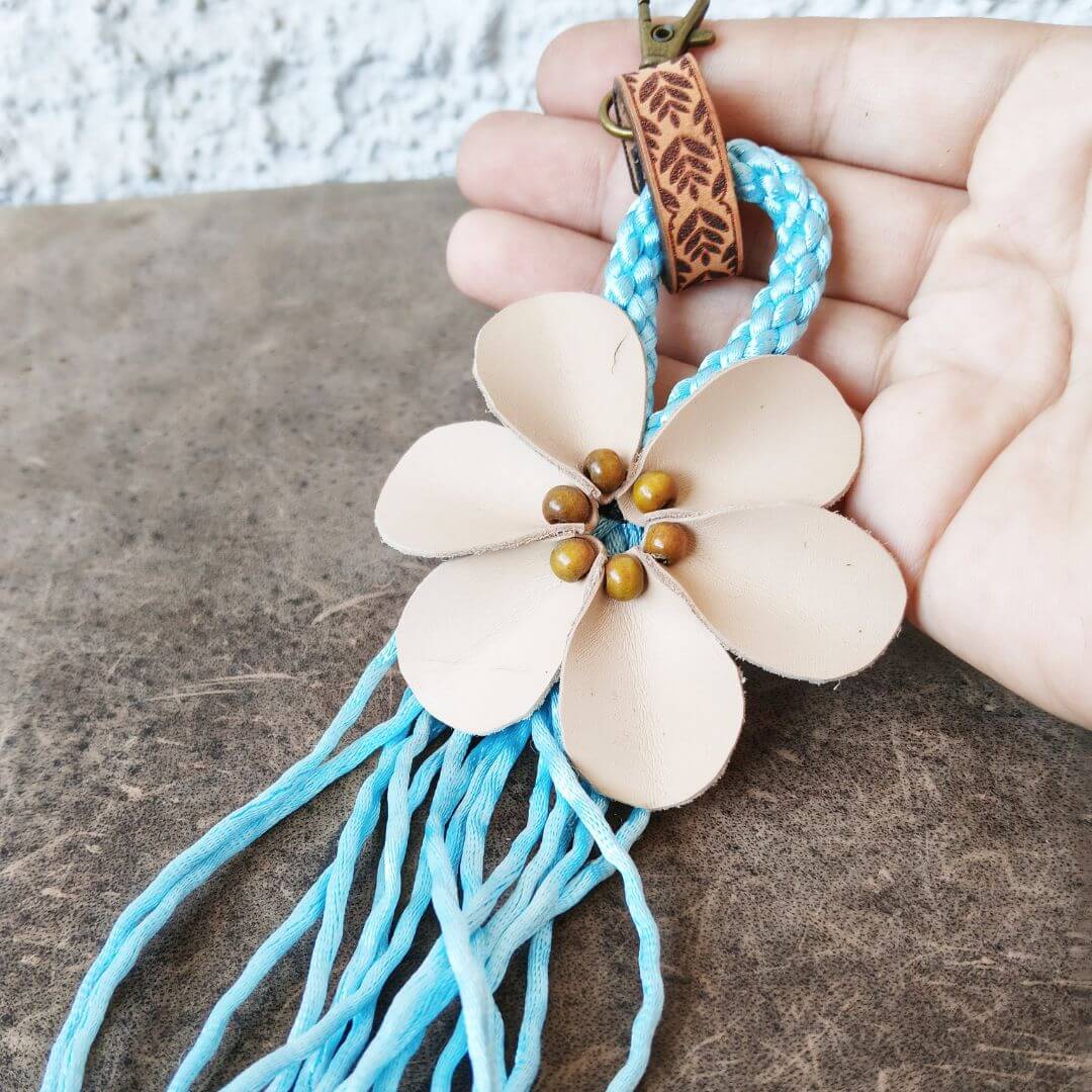 handmade fringe leather flower bag charm held in hand
