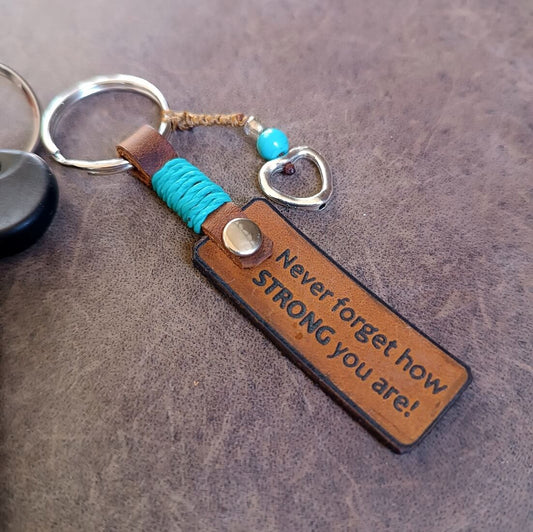 Leather keychain with motivational message on a textured surface